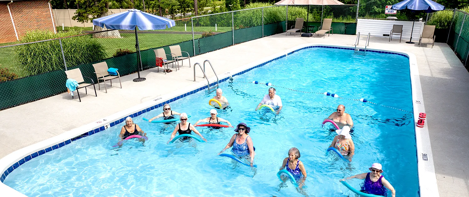 Residents taking water aerobics in the outdoor pool